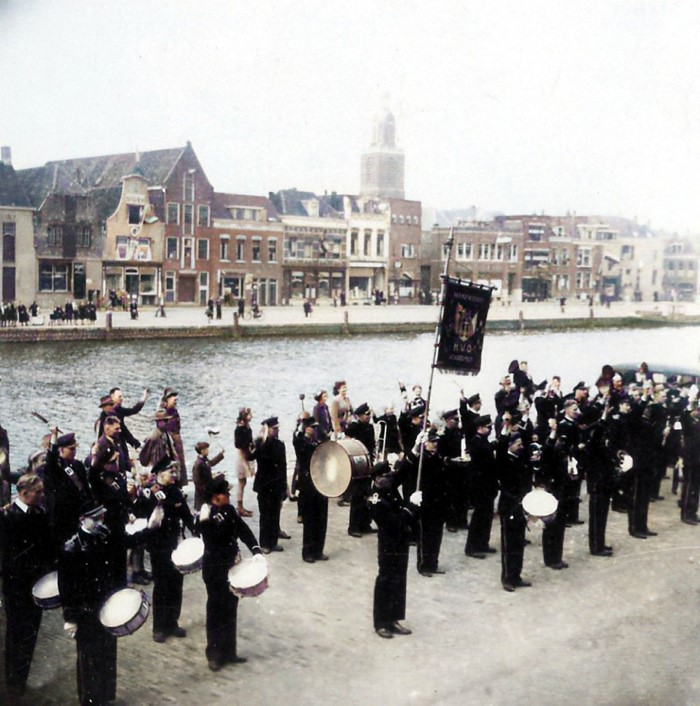 De Harmonievereniging van Havenbedrijf Vlaardingen-Oost (H.V.O.) speelt voor het Hollandiagebouw aan de Oosthavenkade, waar de bevrijdingsoptocht van start gaat. 